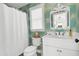 Bright bathroom with vibrant palm wallpaper, featuring a white vanity, toilet and bathtub at 164 River Green Pl, Charleston, SC 29492