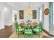 Elegant dining room with a round table, green chairs, decorative curtains, and a chandelier, perfect for Gathering gatherings and formal meals at 164 River Green Pl, Charleston, SC 29492