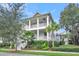 Charming two-story home featuring double porches, a landscaped yard with palm trees, and a classic coastal design at 164 River Green Pl, Charleston, SC 29492