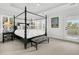 Relaxing main bedroom features a four poster bed, zebra bench, neutral walls, and balcony access at 164 River Green Pl, Charleston, SC 29492