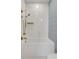 Modern bathroom features white subway tile, updated brass fixtures, and glass shower panel at 179 Wentworth St, Charleston, SC 29401