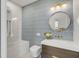 Chic bathroom with grey patterned tile accent wall, a round mirror, and updated fixtures at 179 Wentworth St, Charleston, SC 29401