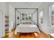 Bright bedroom featuring hardwood floors, a four-poster bed, and natural light from the large windows at 179 Wentworth St, Charleston, SC 29401