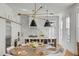 Modern kitchen and dining area featuring an island with seating and designer lighting at 179 Wentworth St, Charleston, SC 29401