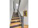 Staircase with wood treads and dark risers leads upstairs with natural light from the window at 179 Wentworth St, Charleston, SC 29401