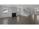 Open living room with a fireplace, hardwood floors, and a staircase, filled with natural light at 2006 Riverbend Dr, Charleston, SC 29412