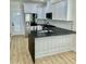 Kitchen view featuring white cabinets, stainless steel appliances, black granite countertops, and hardwood floors at 2035 Beech Ave, North Charleston, SC 29405