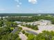 Wide aerial view of a neighborhood showcasing lush green trees and nearby commercial buildings at 204 Tyner Trl, Summerville, SC 29486