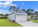 Exterior view showcasing the home's siding, an attached two-car garage, and a well-kept lawn at 206 Pine Crest View Dr, Summerville, SC 29486