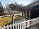 Landscaped backyard featuring a pergola draped with vines and a white picket fence at 209 E 4Th S St, Summerville, SC 29483