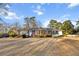 Inviting single-story brick home showcasing a well-kept lawn and tasteful landscaping, blending charm and comfort at 209 E 4Th S St, Summerville, SC 29483