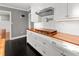 Kitchen with white cabinetry, wooden countertop, tiled backsplash and stainless range hood at 209 E 4Th S St, Summerville, SC 29483