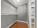Spacious walk-in closet featuring custom shelving, rod, and hardwood floors at 209 E 4Th S St, Summerville, SC 29483