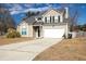 Inviting two-story home showcasing a spacious driveway and neutral siding against a blue sky at 215 Evesham Dr, Summerville, SC 29485
