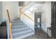 Elegant staircase featuring neutral carpet, white risers, and a wooden handrail at 215 Evesham Dr, Summerville, SC 29485