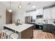 Open-concept kitchen with a white countertop island, stainless steel appliances, and modern pendant lighting at 2200 Belle Isle Ave # 103, Mount Pleasant, SC 29464