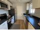 Modern kitchen with white cabinets, stainless steel appliances, hardwood floors and dark countertops at 222 Braly Dr, Summerville, SC 29485
