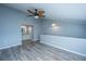 Bright bedroom featuring wood-look floors, modern ceiling fan, and a glimpse into the adjoining bathroom at 2494 Etiwan Ave # B-4, Charleston, SC 29414