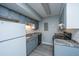Galley kitchen features grey cabinetry, updated appliances, granite counters, and a tile backsplash at 2494 Etiwan Ave # B-4, Charleston, SC 29414