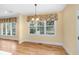 Bright dining area features hardwood floors, large windows with lovely floral valances, and a modern light fixture at 2734 Old Forest Drive, Seabrook Island, SC 29455