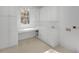 Bright laundry room with white cabinets, a built-in desk, and a window for natural light at 2734 Old Forest Drive, Seabrook Island, SC 29455