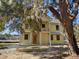 Two-story home with yellow siding, a second-story balcony, and mature trees at 2982 Lodge Berry Ln, Johns Island, SC 29455