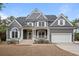 Beautiful two-story gray home with a manicured lawn, welcoming front porch, and a spacious two-car garage at 3004 Riverwood Dr, Mount Pleasant, SC 29466