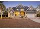 Charming two-story gray home featuring manicured landscaping, inviting front porch, and attached two-car garage at 3004 Riverwood Dr, Mount Pleasant, SC 29466