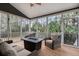 Relaxing screened porch features a seating area with comfortable wicker furniture and a view of the surrounding trees at 3004 Riverwood Dr, Mount Pleasant, SC 29466