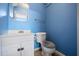 Cozy bathroom featuring a blue paneled wall, toilet and sink at 305 Meadowlark Ln, Moncks Corner, SC 29461
