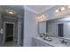 Bathroom with double sink vanity, marble countertop, decorative light fixtures and a large framed mirror at 306 O'Malley Dr, Summerville, SC 29483