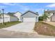 Attached two-car garage with a wide driveway and light blue vinyl siding at 306 O'Malley Dr, Summerville, SC 29483