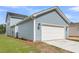 Attached two-car garage with a wide driveway and light blue vinyl siding at 306 O'Malley Dr, Summerville, SC 29483