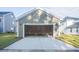 Two-car garage, with open doors and concrete driveway, offers parking and storage at 306 O'Malley Dr, Summerville, SC 29483