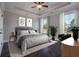 Neutral main bedroom with a tray ceiling, ceiling fan, two windows, and a plush, padded headboard at 306 O'Malley Dr, Summerville, SC 29483