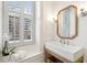 Bright bathroom features a rectangular sink on a wooden stand and a window with white shutters at 32 Tradd St, Charleston, SC 29401