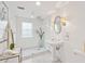 Bright bathroom with glass-enclosed shower, pedestal sink, and modern fixtures at 32 Tradd St, Charleston, SC 29401