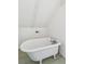 Bright white bathroom with a classic white tub and slanted ceilings at 32 Tradd St, Charleston, SC 29401