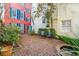 Beautiful brick courtyard with garden greenery, seating, and colorful building exterior at 32 Tradd St, Charleston, SC 29401