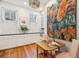 Eat-in kitchen with hardwood floors, two windows, and colorful painting at 32 Tradd St, Charleston, SC 29401