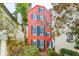 Exterior view of a red building surrounded by lush greenery and a brick patio at 32 Tradd St, Charleston, SC 29401