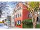 Exterior street view showcases the red brick home with its colorful shutters and landscaping at 32 Tradd St, Charleston, SC 29401