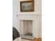 Close-up of the bedroom's white painted fireplace with decorative carvings, and stone hearth at 32 Tradd St, Charleston, SC 29401