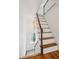 Staircase with dark wood handrail and hardwood treads, illuminated by a modern chandelier at 32 Tradd St, Charleston, SC 29401