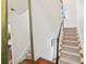 Carpeted staircase with wooden handrail leads to the upper level of this bright home at 32 Tradd St, Charleston, SC 29401