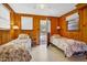 Cozy bedroom with two beds, wood walls, and a door leading to the outside at 3408 Palmetto Blvd, Edisto Island, SC 29438