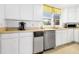 Functional kitchen featuring white cabinetry, stainless steel dishwasher, and ample counter space at 3408 Palmetto Blvd, Edisto Island, SC 29438