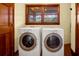 Laundry room featuring a side-by-side washer and dryer, wood-trimmed windows, and a wooden door at 3408 Palmetto Blvd, Edisto Island, SC 29438