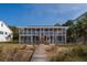 Two story beach home features large screened porches accessible via raised wooden walkway at 3408 Palmetto Blvd, Edisto Island, SC 29438