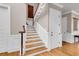 Elegant staircase with wooden steps and white railings, complemented by hardwood floors at 4 Cedar Waxwing Ct, Kiawah Island, SC 29455